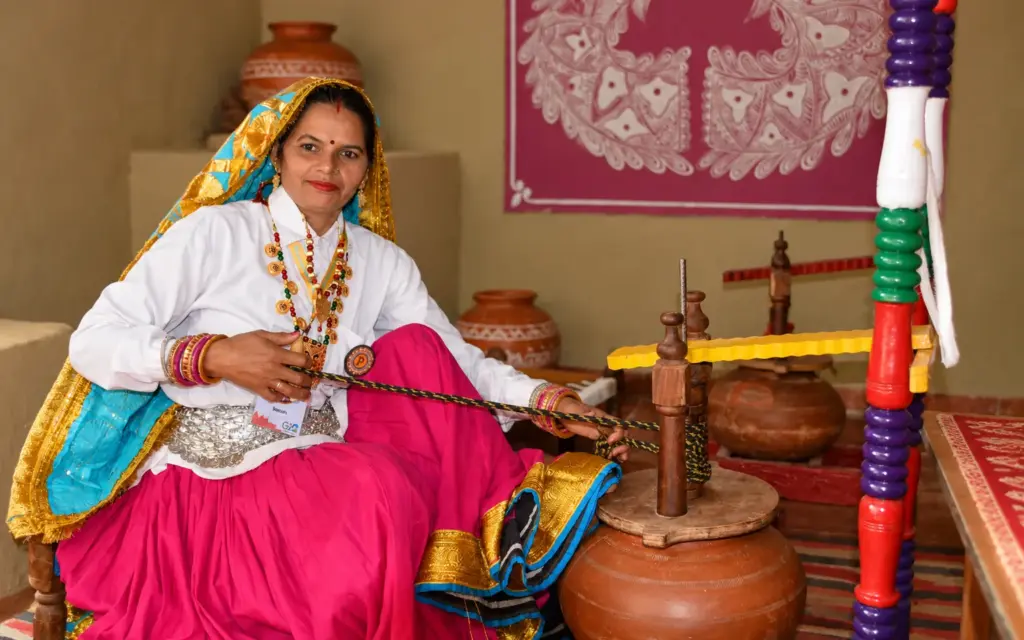 A woman churning curd with a wooden bilona at the farm